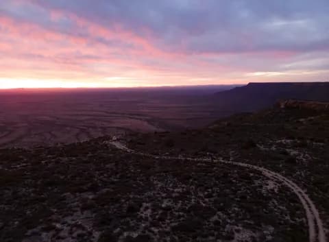 The open plain and winding tracks beneath a pink evening sky