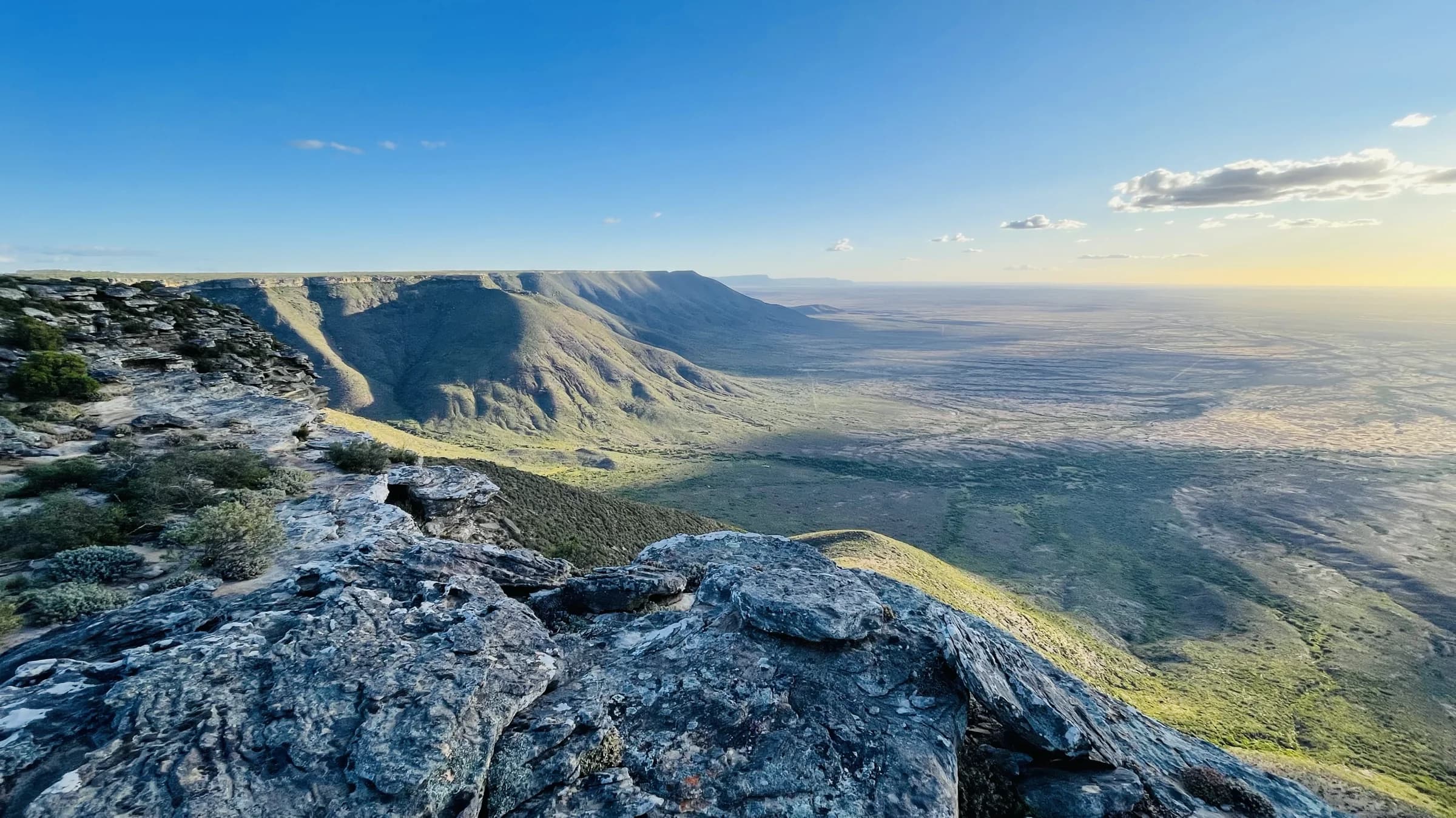 Rock ledges on the escarpment above a green plain